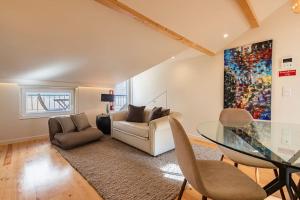 Sacramento Terrace Apartment في لشبونة: غرفة معيشة مع أريكة وطاولة زجاجية