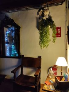 a room with a chair and a table with a lamp at La casa de la abuela Amalia in Arenas de San Pedro
