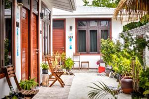 a front porch of a house with plants at Suvaasa Inn in Omadhoo
