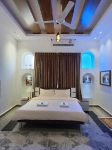 a bedroom with a large bed and a ceiling at Valley CLIFF INN in Al Jināh