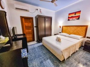 um quarto com uma cama grande num quarto em Suvaasa Inn em Omadhoo