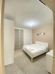- une chambre blanche avec un lit dans l'établissement Castramajora Alloggi, à Casalmaggiore