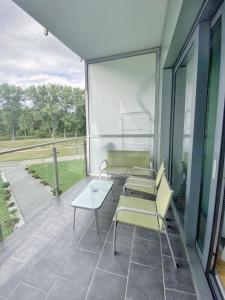 a patio with chairs and a table and a window at Capital Towers - Apartament Pop-art z widokiem na rzekę in Rzeszów