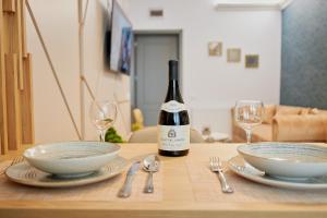 a bottle of wine sitting on top of a table with plates at UpTown Apartments in Iaşi