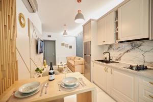 una cocina con armarios blancos y una mesa con platos. en UpTown Apartments, en Iaşi