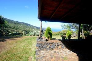 a stone wall with a view of the ocean at La Herbilla in Garafía