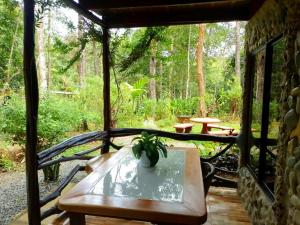 a porch with a bench and a table with a plant at Cabaña Eco-Arte in Tortugal
