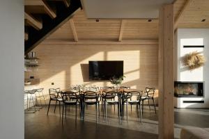 a dining room with a table with chairs and a tv at be be Chalet - premium jacuzi & private pool in Bukovel