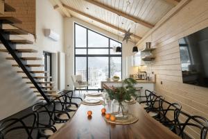 a dining room with a long wooden table and chairs at be be Chalet - premium jacuzi & private pool in Bukovel