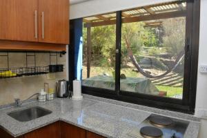 cocina con fregadero y ventana grande en La Salamandra. Casa en la Sierra en Tandil
