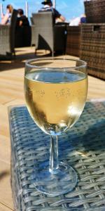 a glass of white wine sitting on a table at Beach Holiday Home - Pet Friendly in Llanina