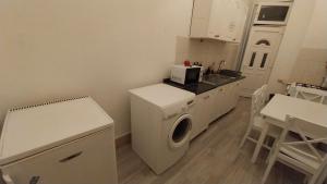 cocina con lavadora y fregadero en Retro Rooms, en Budapest