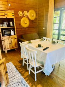 ein Esszimmer mit einem Tisch und weißen Stühlen in der Unterkunft Casa aconchego da praia miseria frente mar in Bombinhas