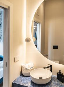 a bathroom with a white sink and a mirror at LA BANCHINA LUXURY SUITES in Trani +43 photos