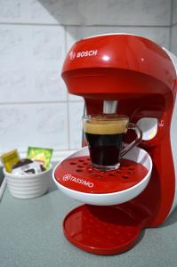 a red coffee maker with a cup of coffee at Ευρύχωρο διαμέρισμα στο κέντρο της πόλης in Kastoria