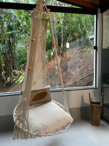 eine hängende Hängematte in einem Zimmer mit Fenster in der Unterkunft Pousada Chácara Aracê in Araras Petropolis