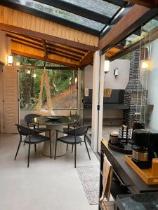 a dining room with a table and chairs and a patio at Pousada Chácara Aracê in Araras Petropolis