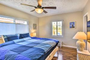- une chambre avec un lit bleu et un ventilateur de plafond dans l'établissement Cozy Cocoa Beach Bungalow - Walk to Beach and Pier!, à Cocoa Beach