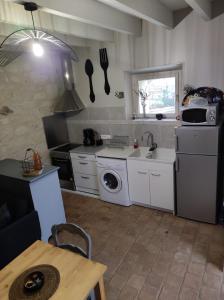 a kitchen with a sink and a washing machine at La tour du Grand Boust in Longué +3 photos