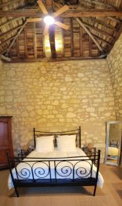 a bedroom with a bed with a ceiling fan at La tour du Grand Boust in Longué