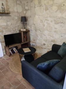 a living room with a couch and a tv at La tour du Grand Boust in Longué