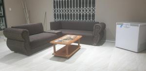 a living room with a couch and a coffee table at Kailas Guest in Queensburgh