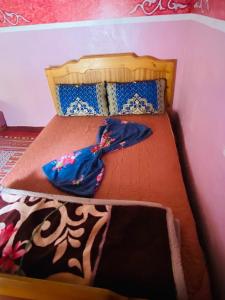 a small bed with a blue umbrella on it at Taghia Gîte du Grimpeur in Taghia