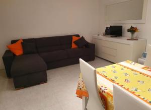 ein Wohnzimmer mit schwarzem Sofa und einem Tisch in der Unterkunft MaryAlex in Punta Secca