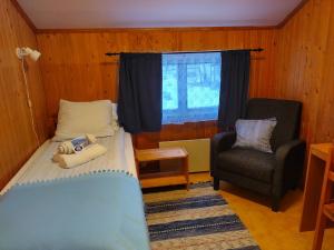 um quarto com uma cama, uma cadeira e uma janela em Hammarstrand Budget Hotell- Lergodset em Hammarstrand