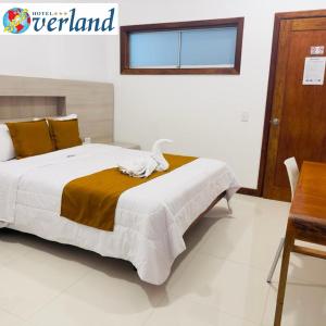 a bedroom with a large bed and a table at Hotel Overland in Paracas