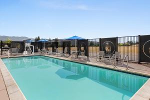 a swimming pool with chairs and umbrellas at Holiday Inn Express & Suites - Ukiah, an IHG Hotel in Ukiah