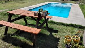 una mesa de picnic de madera junto a una piscina en L' AMORE DELLA NONNA en San Rafael