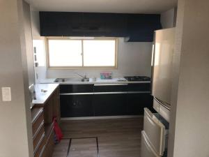 a kitchen with a sink and a refrigerator and a window at Rusutsu Washi House in Rusutsu