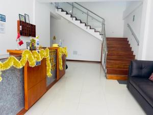 a living room with a staircase and a table with yellow bows at Hotel Overland in Paracas