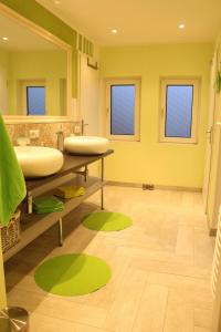 a bathroom with two sinks and a large mirror at Haus-Luise in Poppenbüll