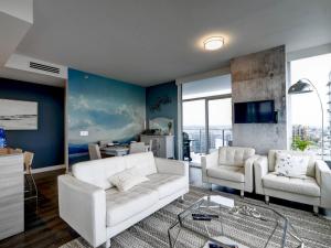 un soggiorno con un divano bianco e 2 sedie di Admiral's Anchor by IRIS PROPERTIES! a Victoria