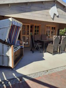 a patio with a table and chairs and an umbrella at Haus-Luise in Poppenbüll