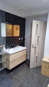 a bathroom with a sink and a wooden door at Apartment Panorama 35C in Donovaly