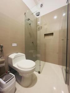 La salle de bains est pourvue de toilettes et d'une douche en verre. dans l'établissement Hotel Overland, à Paracas