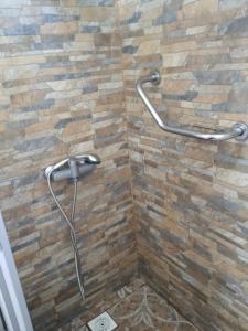 a shower with a stone wall and a shower head at Verde Paz in Curacautín