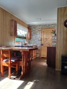 a kitchen with a wooden table and a counter at Verde Paz in Curacautín