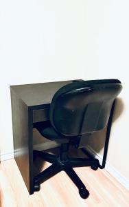 a black desk with a black chair next to a wall at 2 BDRM A/C Condo w/Ensuite Laundry + Free Parking in Edmonton