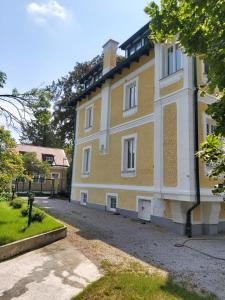 ein großes gelbes und weißes Gebäude mit Auffahrt in der Unterkunft Haus Gaaden in Gaaden