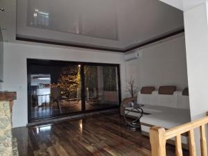a living room with a large window and a table at Vila Odiseas in Belgrade
