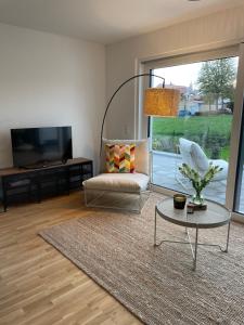 a living room with a couch and a table and a tv at Traumhaft helle Wohnung mit Sonnenterrasse in Worms