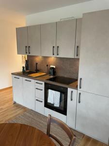 uma cozinha com armários brancos e um forno com placa de fogão em Traumhaft helle Wohnung mit Sonnenterrasse em Worms