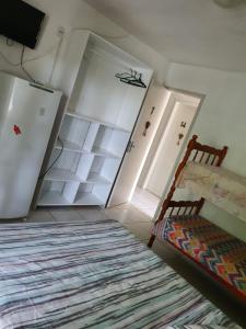 um pequeno quarto com uma cama e um armário em Pousada Charle Brown em Garopaba