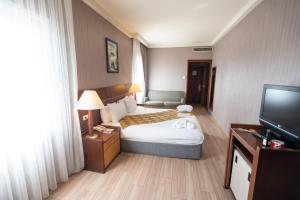um quarto de hotel com uma cama e uma televisão de ecrã plano em The Green Park Bostancı em Istambul