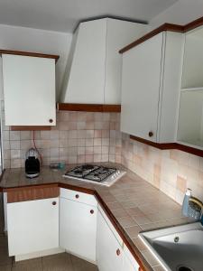 uma cozinha com armários brancos e um fogão em Appartement Cosy Pointe-à-Pitre em Pointe-à-Pitre
