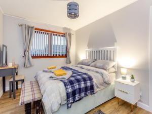 a bedroom with two beds and a desk at Parkhill Cottage in Kildary